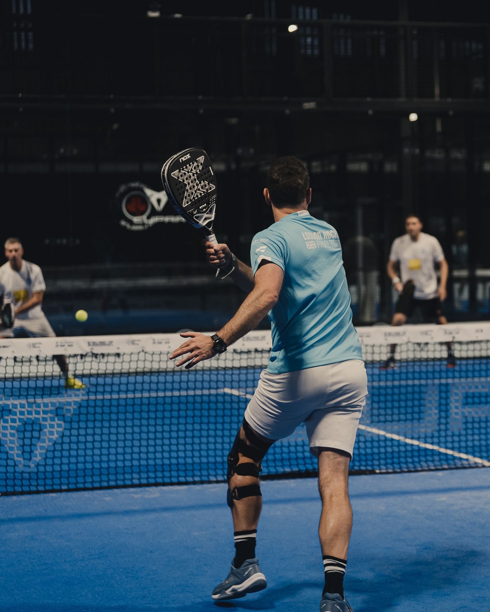 An English player plays a forehand at the net