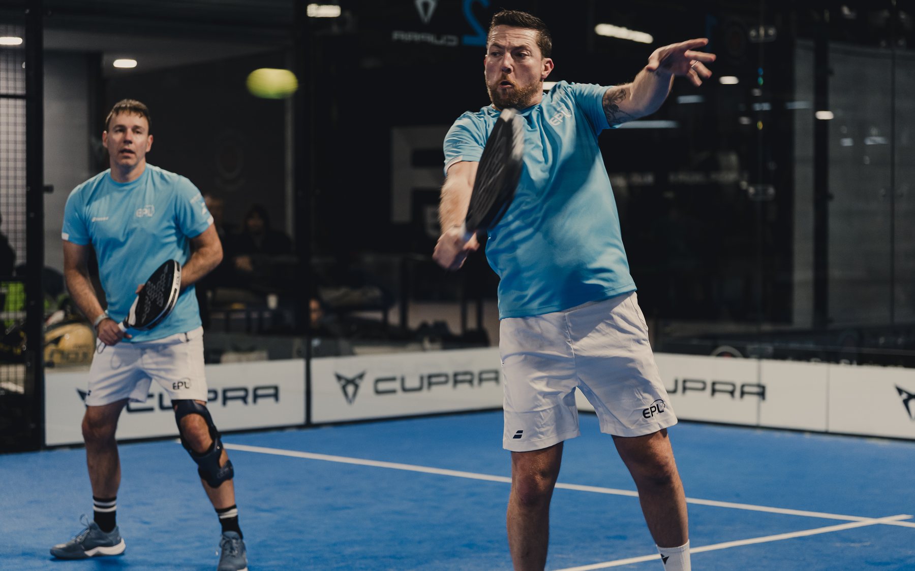 Two players at the net during a tournament at Padel54